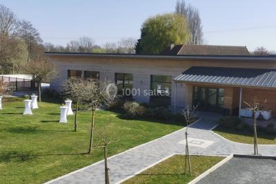 Étang entouré d'arbres illuminés la nuit, avec leurs reflets visibles sur l'eau calme.