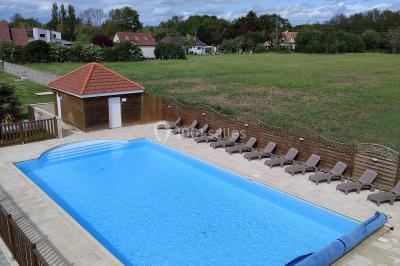 Étang entouré d'arbres illuminés la nuit, avec leurs reflets visibles sur l'eau calme.