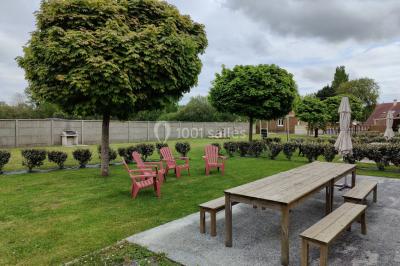 Étang entouré d'arbres illuminés la nuit, avec leurs reflets visibles sur l'eau calme.