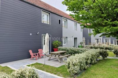 Étang entouré d'arbres illuminés la nuit, avec leurs reflets visibles sur l'eau calme.