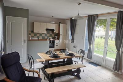 Étang entouré d'arbres illuminés la nuit, avec leurs reflets visibles sur l'eau calme.