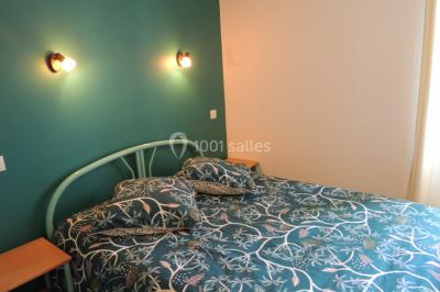 Étang entouré d'arbres illuminés la nuit, avec leurs reflets visibles sur l'eau calme.