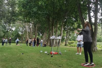 Étang entouré d'arbres illuminés la nuit, avec leurs reflets visibles sur l'eau calme.
