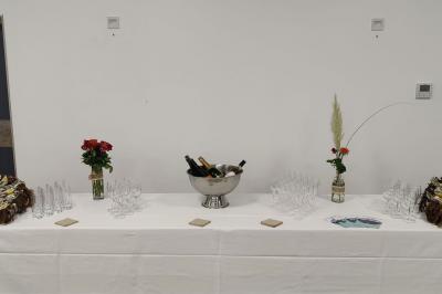 Étang entouré d'arbres illuminés la nuit, avec leurs reflets visibles sur l'eau calme.