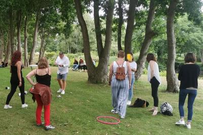 Étang entouré d'arbres illuminés la nuit, avec leurs reflets visibles sur l'eau calme.