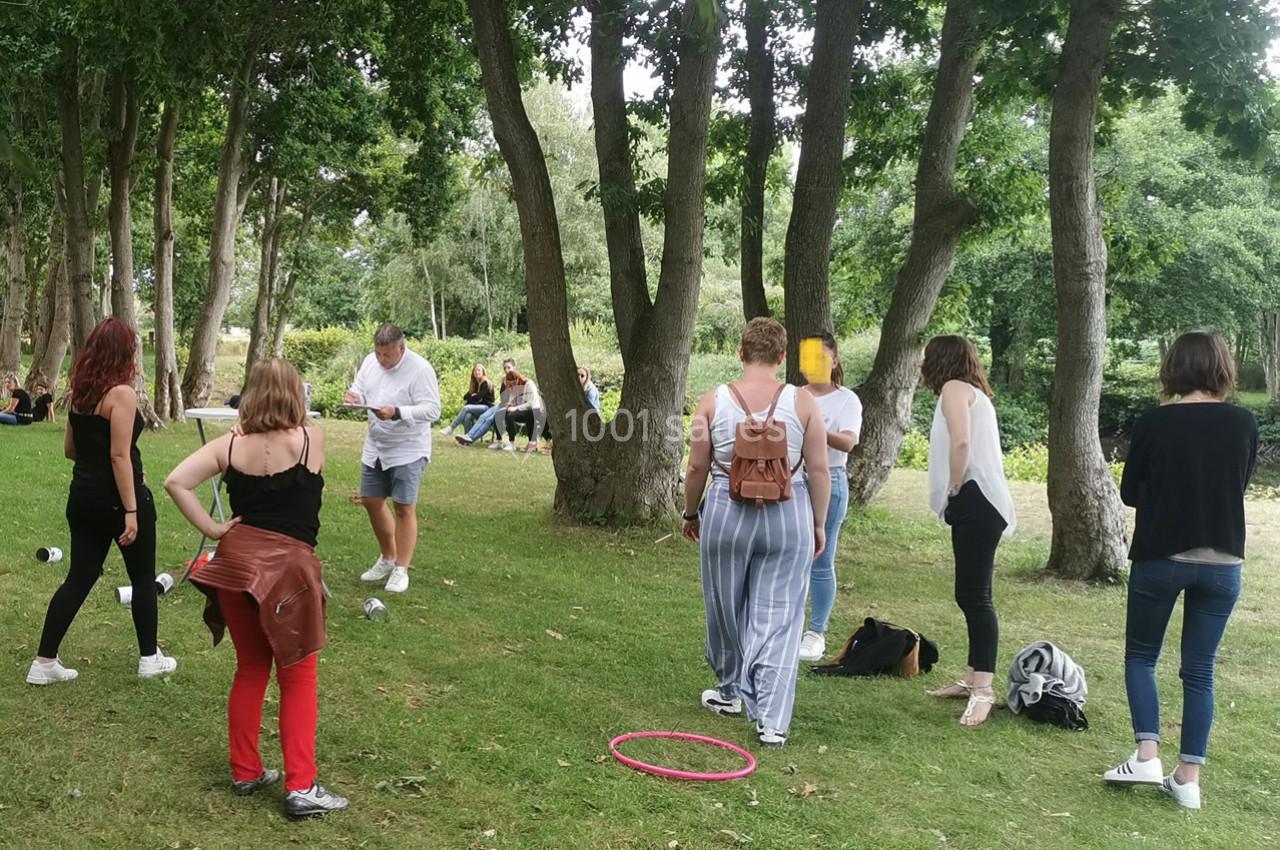 Un groupe de personnes debout dans un parc, entouré d'arbres, participant à une activité en plein air.