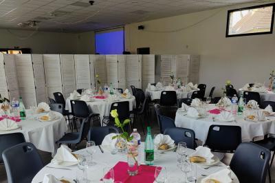 Étang entouré d'arbres illuminés la nuit, avec leurs reflets visibles sur l'eau calme.