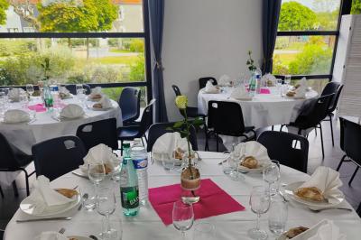 Étang entouré d'arbres illuminés la nuit, avec leurs reflets visibles sur l'eau calme.