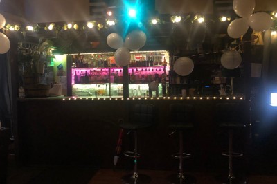 Enseigne lumineuse indiquant ’Restaurant L'Essentiel Café’ sur une façade sombre.