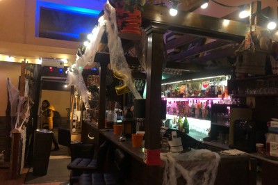 Enseigne lumineuse indiquant ’Restaurant L'Essentiel Café’ sur une façade sombre.