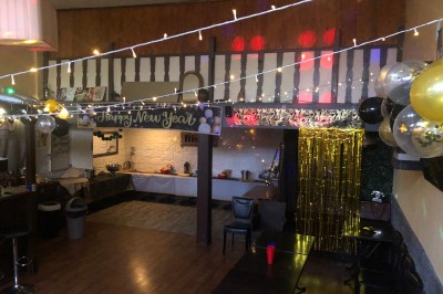 Enseigne lumineuse indiquant ’Restaurant L'Essentiel Café’ sur une façade sombre.