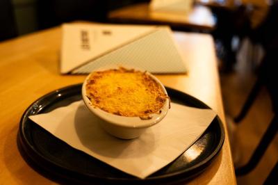 Bol de salade garnie de morceaux de poulet croustillant, posé sur une table en bois dans un restaurant.
