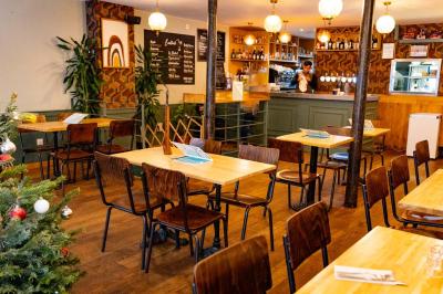 Bol de salade garnie de morceaux de poulet croustillant, posé sur une table en bois dans un restaurant.