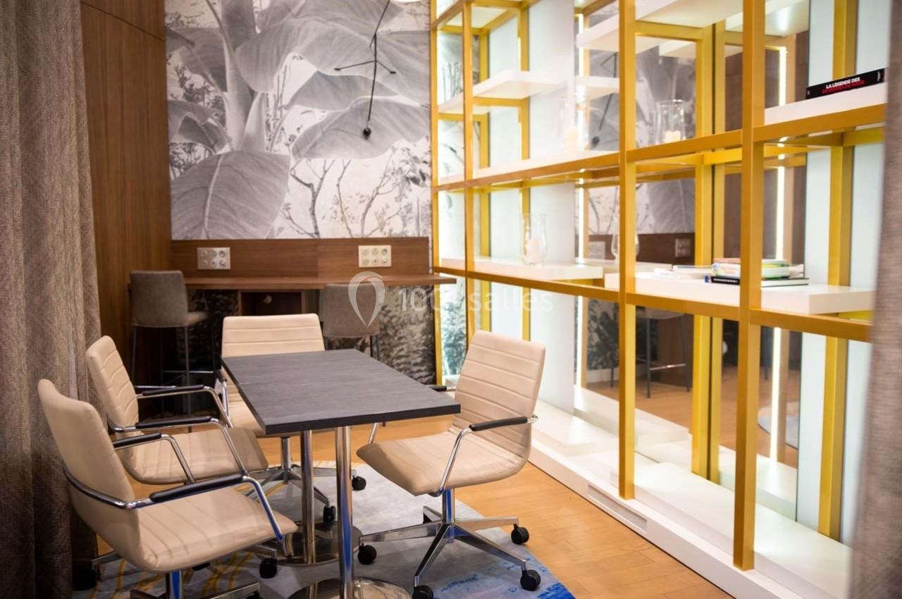 Salle de réunion moderne avec table, chaises pivotantes, étagères jaunes et mur décoré d'une fresque végétale.