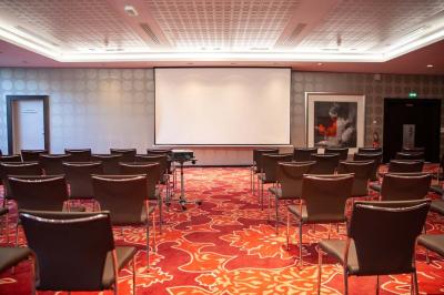 Salle de bain moderne avec baignoire, douche, double vasque, miroir large et serviettes blanches.
