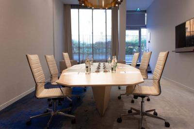 Salle de bain moderne avec baignoire, douche, double vasque, miroir large et serviettes blanches.