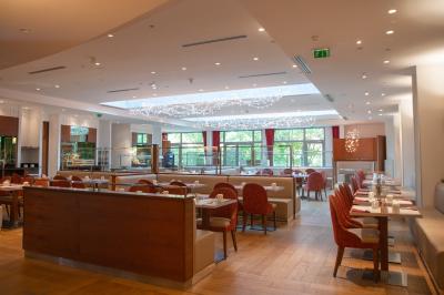Salle de bain moderne avec baignoire, douche, double vasque, miroir large et serviettes blanches.