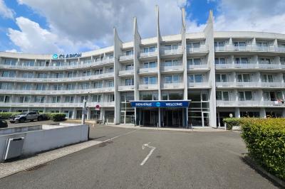 Salle de bain moderne avec baignoire, douche, double vasque, miroir large et serviettes blanches.