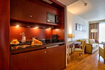 Salle de bain moderne avec baignoire, douche, double vasque, miroir large et serviettes blanches.