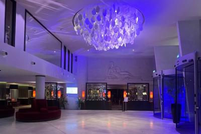 Salle de bain moderne avec baignoire, douche, double vasque, miroir large et serviettes blanches.