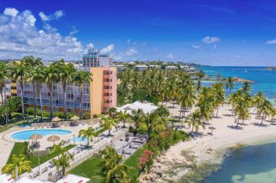 Salle de réunion avec tables disposées en U, chaises bleues et rouges, éclairage au plafond et sol carrelé beige.