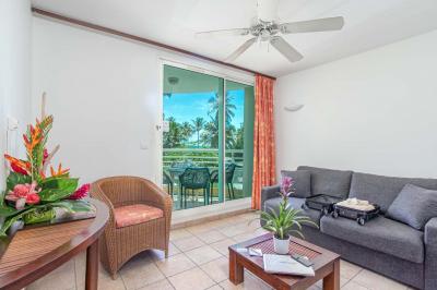 Salle de réunion avec tables disposées en U, chaises bleues et rouges, éclairage au plafond et sol carrelé beige.