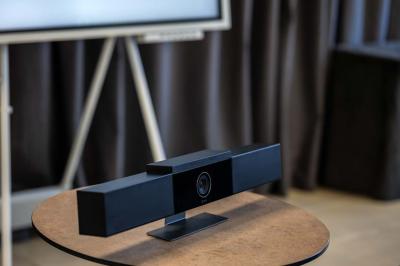 Chambre lumineuse avec lit double, mobilier en bois, télévision et balcon offrant une vue sur des palmiers.