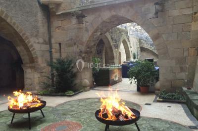Grande table dressée en extérieur avec vaisselle, décorations florales et citrons, entourée de chaises en bois.