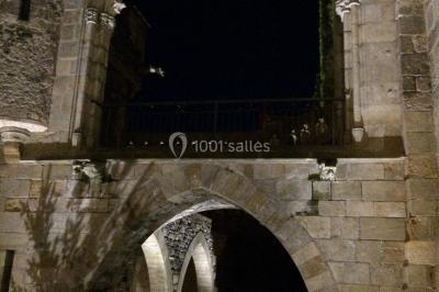 Grande table dressée en extérieur avec vaisselle, décorations florales et citrons, entourée de chaises en bois.