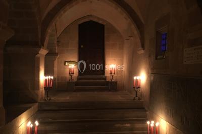 Grande table dressée en extérieur avec vaisselle, décorations florales et citrons, entourée de chaises en bois.