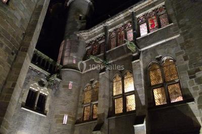 Grande table dressée en extérieur avec vaisselle, décorations florales et citrons, entourée de chaises en bois.