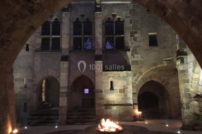 Grande table dressée en extérieur avec vaisselle, décorations florales et citrons, entourée de chaises en bois.