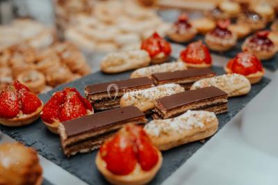 Grande table dressée en extérieur avec vaisselle, décorations florales et citrons, entourée de chaises en bois.
