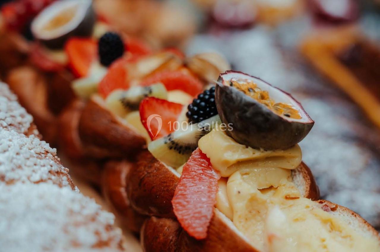 Brioche garnie de fruits frais comme fraises, kiwis, mûres et fruit de la passion, avec une crème onctueuse.