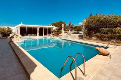 Salle lumineuse avec tables rectangulaires, chaises noires et verrerie suspendue, donnant sur de grandes fenêtres.