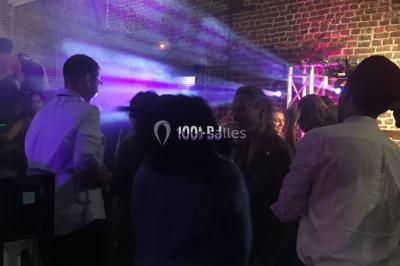 Miroir interactif encadré de lumières, posé sur un tapis rouge avec des chapeaux colorés à proximité.