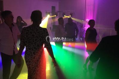 Miroir interactif encadré de lumières, posé sur un tapis rouge avec des chapeaux colorés à proximité.