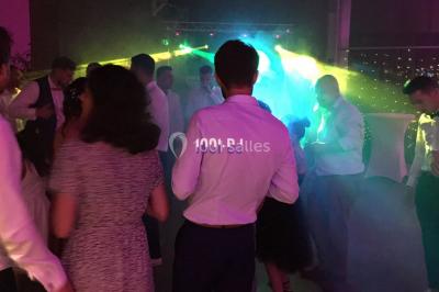 Miroir interactif encadré de lumières, posé sur un tapis rouge avec des chapeaux colorés à proximité.