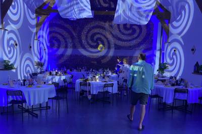 Miroir interactif encadré de lumières, posé sur un tapis rouge avec des chapeaux colorés à proximité.