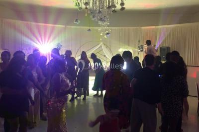 Des personnes dansent sous des lumières colorées dans une ambiance festive en intérieur.