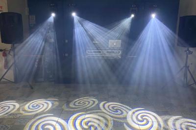 Des personnes dansent sous des lumières colorées dans une ambiance festive en intérieur.