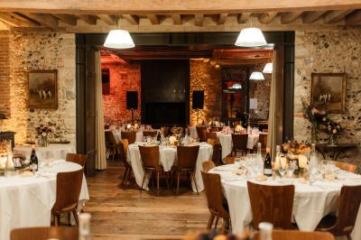 Un couple de dos observe des lanternes volantes dans un cadre nocturne entouré de convives.