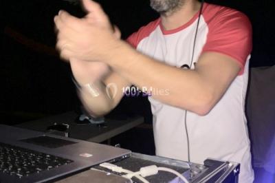 Poste de DJ éclairé par des lumières violettes, entouré de décorations d'Halloween et de toiles d'araignée.