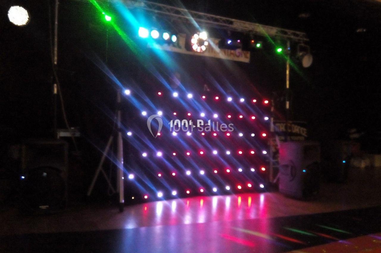 Mur lumineux avec des LED colorées formant des motifs, installé dans une salle sombre pour un événement festif.