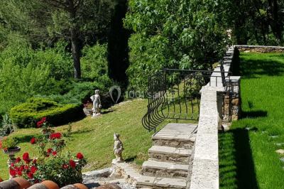 Allée en béton fraîchement coulée, éclairée par des lampadaires, entourée d'arbres et de végétation la nuit.