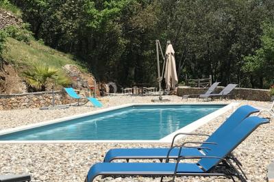 Allée en béton fraîchement coulée, éclairée par des lampadaires, entourée d'arbres et de végétation la nuit.