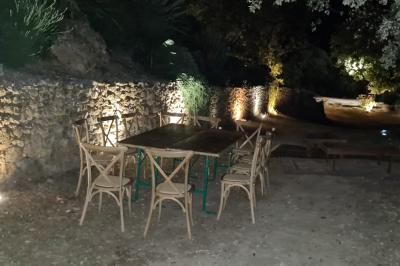 Allée en béton fraîchement coulée, éclairée par des lampadaires, entourée d'arbres et de végétation la nuit.