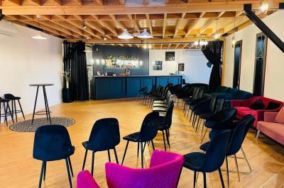 Table en bois avec viennoiseries, jus d'orange, verres et carafe devant une fresque murale colorée sur le café.