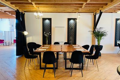 Table en bois avec viennoiseries, jus d'orange, verres et carafe devant une fresque murale colorée sur le café.