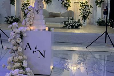 Un groupe de personnes en tenue traditionnelle célèbre un événement sous des lustres dans une grande salle éclairée.